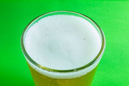cold glass of beer on green backgroundの写真素材