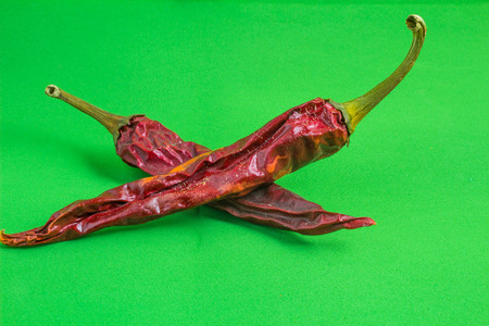 old red chili pepper on a green backgroundの写真素材