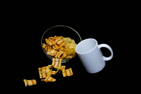 Potato chips in glass bowl on black backgroundの写真素材
