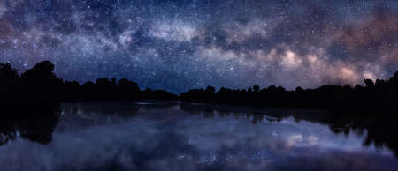 Panoramic picture of starry night sky over the lakeの写真素材