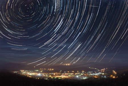 A picture of star tracks over mountain townの写真素材