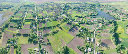 Aerial panorama of the picturesque countryside with many fields and gardens