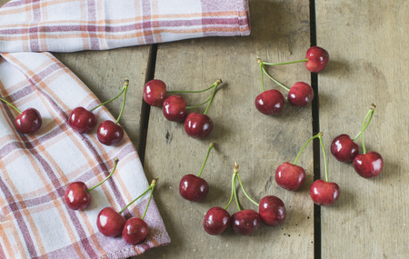 Fresh cherries on old, rustic wooden background.の写真素材