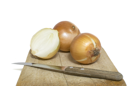 Unpeeled Onions Sit On An Isolated Chopping Boardの写真素材