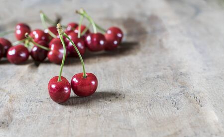Fresh cherries on old, rustic wooden background.