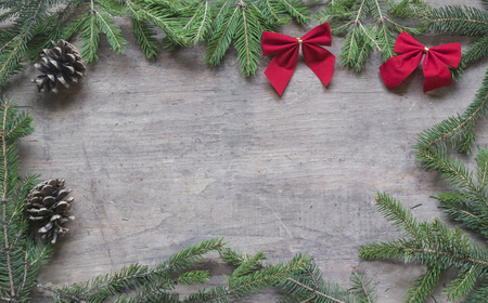 Frame from pine branches and christmas decoration with copy space on wooden background.の写真素材