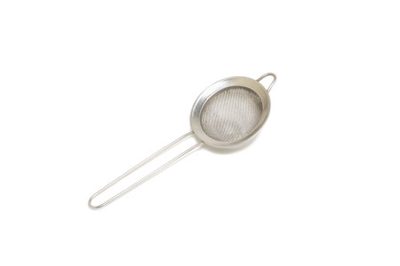 Round metal tea strainer isolated on white.