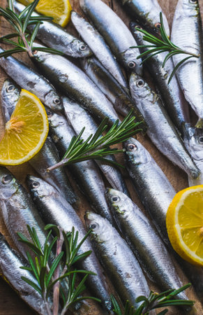 Full frame photo of fresh and frozen sardines with lemon and rosemary.