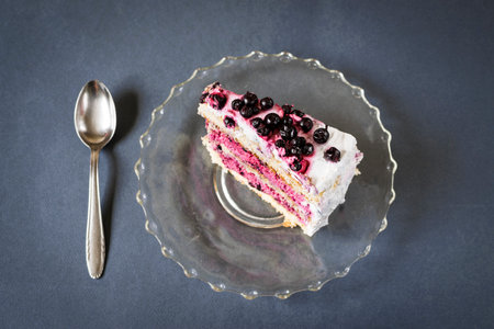 Piece of blueberry cake and spoon on blue backgroundの写真素材