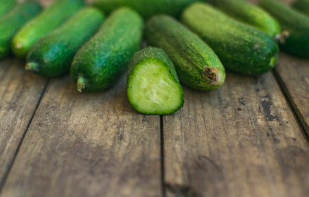 Fresh cucumbers on old wooden table. Selective focus and place for textの写真素材