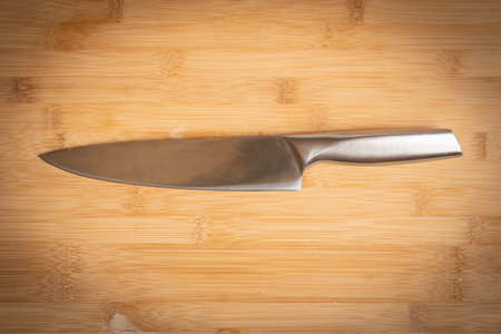 Kitchen knife made of steel on wooden table.の写真素材
