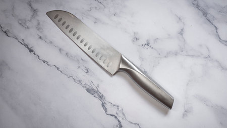 Kitchen knife made of steel on marble table.の写真素材