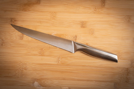 Kitchen knife made of steel on wooden table.の写真素材