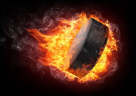 Hockey Puck in fire Isolated on Black Backgroundの写真素材
