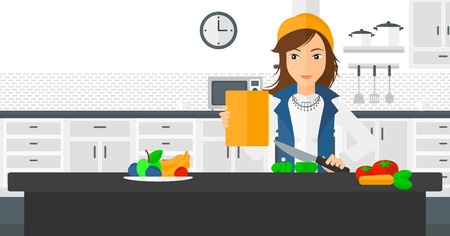 A woman standing in the kitchen with a digital tablet in a hand and cutting vegetables on cutting board vector flat design illustration. Horizontal layout.のイラスト素材