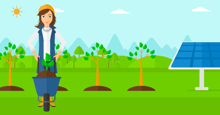 A woman standing with a plant and soil in a wheelbarrow on a background with newly planted trees and solar panels vector flat design illustration. Horizontal layout.のイラスト素材