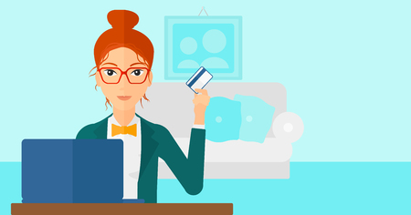 A woman sitting in front of laptop with credit card in hand and making purchases online on the background of living room vector flat design illustration. Horizontal layout.のイラスト素材