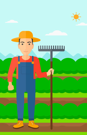 A man standing with a rake on the background of field rows with green bushes vector flat design illustration. Vertical layout.のイラスト素材