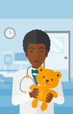 An african-american pediatrician holding a teddy bear on the background of hospital ward vector flat design illustration. Vertical layout.のイラスト素材