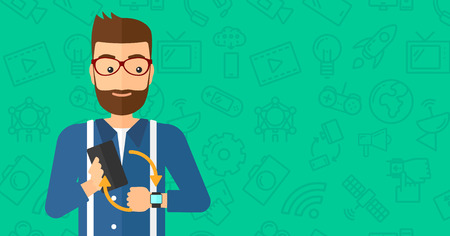 A hipster man with the beard holding a smartphone and looking at his smart watch on a green background with technology icons vector flat design illustration. Horizontal layout.のイラスト素材