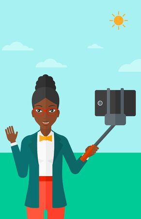 An african-american woman making selfie with a selfie-stick on the background of blue sky vector flat design illustration. Vertical layout.のイラスト素材