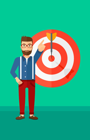 A hipster man with the beard pointing at arrow in a target board on a green background vector flat design illustration. Vertical layout.のイラスト素材
