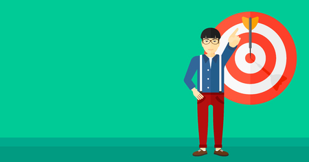 An asian man pointing at arrow in a target board on a green background vector flat design illustration. Horizontal layout.のイラスト素材