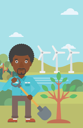 An african-american man with the shovel plants a tree on a background with wind turbins vector flat design illustration. Vertical layout.のイラスト素材