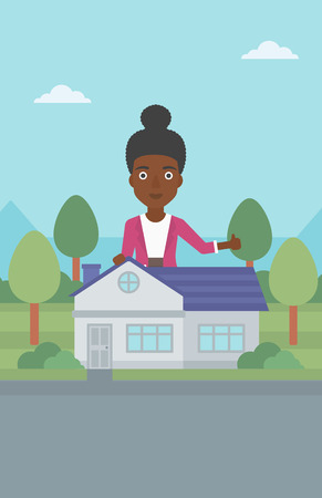 An african-american woman standing behind the house and showing thumb up. Female real estate agent offering the house. Young woman giving thumb up. Vector flat design illustration. Vertical layout.のイラスト素材