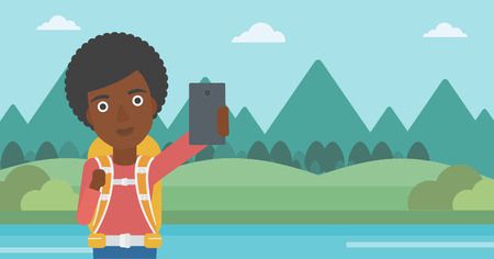 An african-american woman making selfie on the background of mountains. Travelling woman with backpack taking photo with cellphone. Vector flat design illustration. Horizontal layout.のイラスト素材
