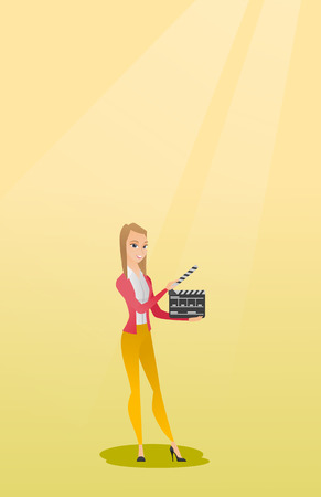 Smiling woman holding an open clapperboard.のイラスト素材