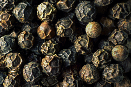 Macro photography of black peppercorns in dark tones top view