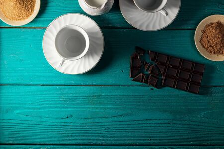 Ingredients and equipment to make hot chocolate with whipped cream (viennois) on a teal wooden backdrop, with space for text, top viewの写真素材
