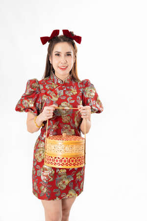 Chinese New Year concept, Woman holding a basket of food ,meaning to be happy healthy and wealthy year, Chinese New Year Celebration Conceptの写真素材