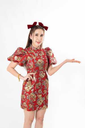 Happy Asian woman wearing traditional cheongsam qipao dress and hand gesture up pointing up to copy space isolated on White background. Happy Chinese new year Women with Happy Expression Conceptの写真素材