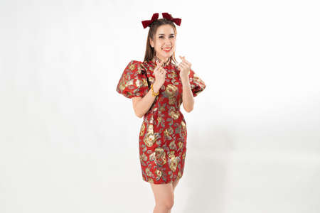 Happy Asian woman wearing traditional cheongsam qipao dress isolated on White background. Happy Chinese new year Women with Happy Expression Conceptの写真素材