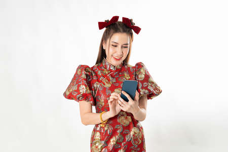 Asian woman wearing chinese dress with mobile smart phone shopping online technology cheongsam,qipao concept on white isolated backgroundの写真素材