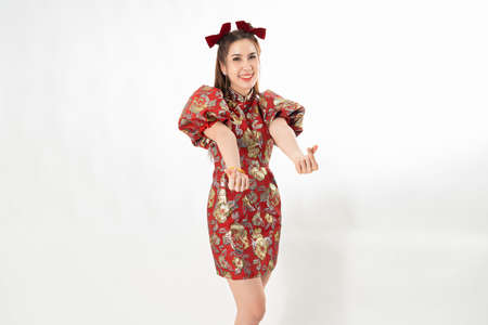 Happy Asian woman wearing traditional cheongsam qipao dress isolated on White background. Happy Chinese new year Women with Happy Expression Conceptの写真素材