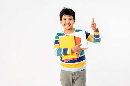 Portrait of Happy asian boy with laptop and books isolated on white background, Education and learning with technology conceptの写真素材