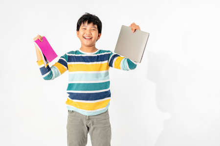 Portrait of Happy asian boy with laptop and books isolated on white background, Education and learning with technology conceptの写真素材