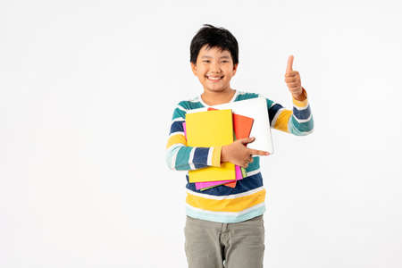 Portrait of Happy asian boy with laptop and books isolated on white background, Education and learning with technology conceptの写真素材