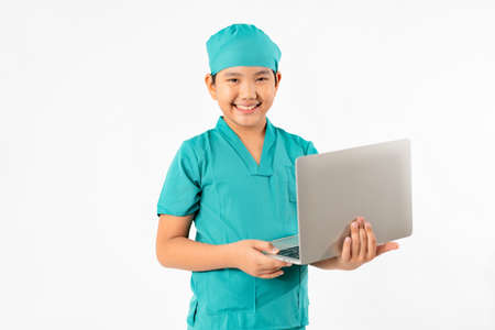 Portrait of Young Asian Boy Dressing to be Doctor, Holding Laptop Isolate on White Background, Education Conceptの写真素材
