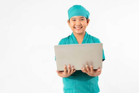 Portrait of Young Asian Boy Dressing to be Doctor, Holding Laptop Isolate on White Background, Education Conceptの写真素材