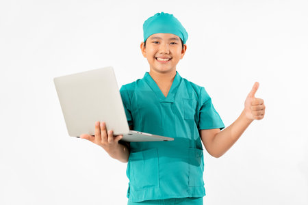 Portrait of Young Asian Boy Dressing to be Doctor, Holding Laptop Isolate on White Background, Education Conceptの写真素材