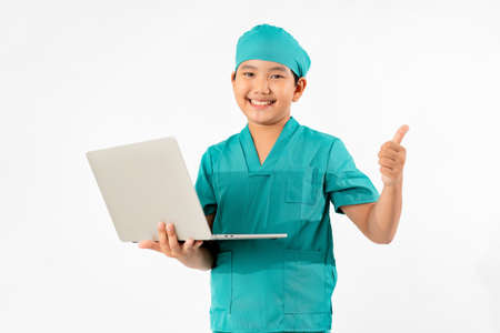 Portrait of Young Asian Boy Dressing to be Doctor, Holding Laptop Isolate on White Background, Education Conceptの写真素材
