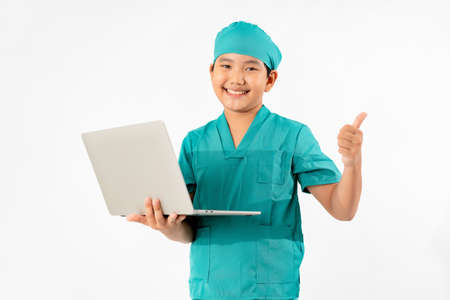 Portrait of Young Asian Boy Dressing to be Doctor, Holding Laptop Isolate on White Background, Education Conceptの写真素材