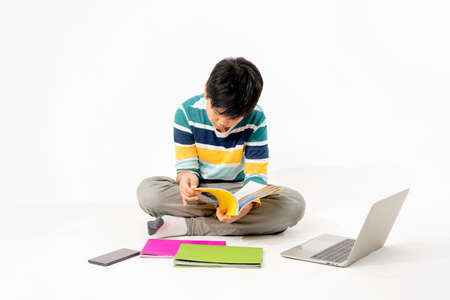 Portrait of Happy asian boy on floor with laptop and books isolated on white background, Education...