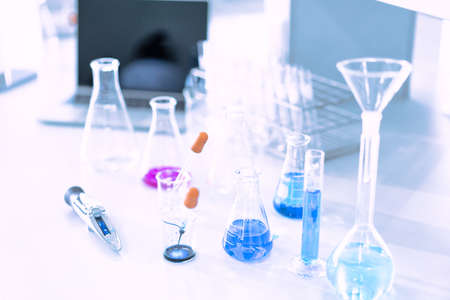 glass flask in chemical science education laboratory with molecular structure in blue backgroundの写真素材