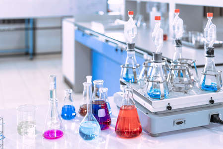glass flask in chemical science education laboratory with molecular structure in blue backgroundの写真素材