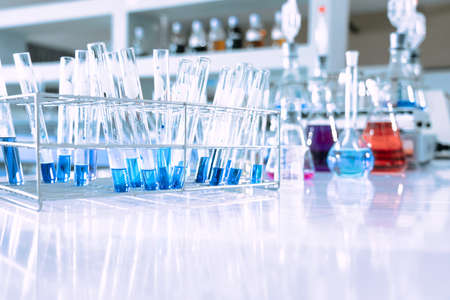 glass flask in chemical science education laboratory with molecular structure in blue background